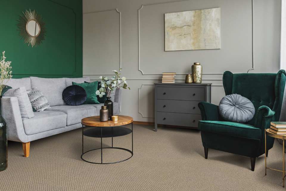 living room with green painted accent wall and velvet green accents